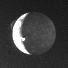 Historische niedrig aufgelöste Voyager-Ansicht von Io: heller beleuchteter Rand und eine über den Mondrand ragende vulkanische Wolke