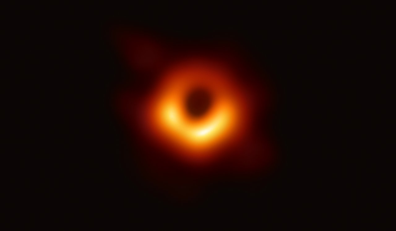 Rekonstruierte Radioaufnahme von M87*: ein ungleichmäßig heller orangefarbener Ring um eine dunkle Schattenregion