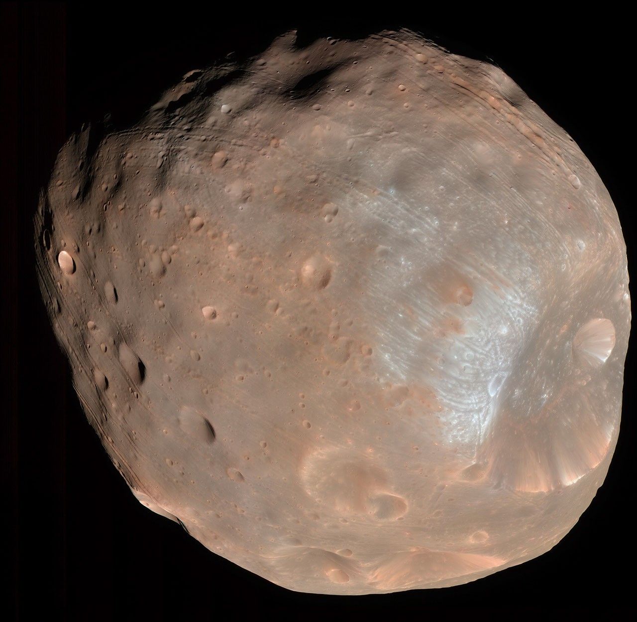 Unregelmäßig geformter Phobos mit großem Krater Stickney, kleineren Kratern und Rillen, in einer farbverstärkten MRO-Aufnahme